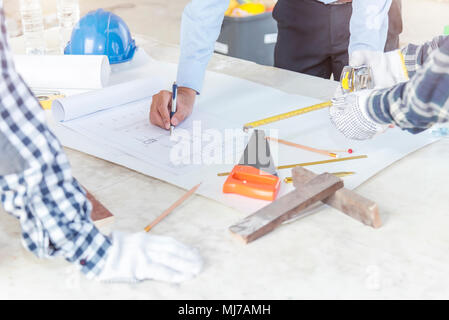 Civil engineer and foreman meeting and working on blueprint. Architects workplace, architectural project blueprints ruler calculator. Stock Photo