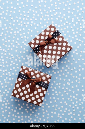 Christmas Gift Boxes with snow confetti over blue background, above view Stock Photo