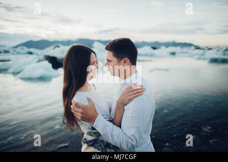 Young stylish  couple in love in Iceland. Woman and man embrace and want to kiss each other. Lovely couple kissing in glacier lagoon in Iceland. Stock Photo