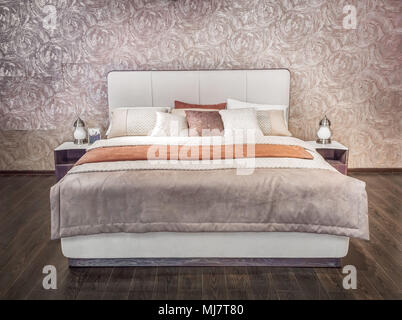 Luxury gray beige modern bed furniture with patterned bed with leather upholstery headboard . Soft brocade fabric bed. Classic modern furniture in hom Stock Photo