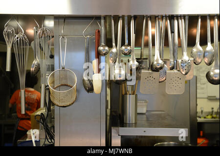 Cooking utensils hanging up in a kitchen in a large restaurant Stock Photo