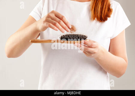 Women's Hair Loss. Beautiful redhair with hair tuft in hair isolated. Stock Photo