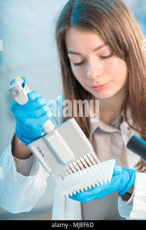 student woman with multi pipette and other PCR items in microbiological / genetic laboratory Stock Photo