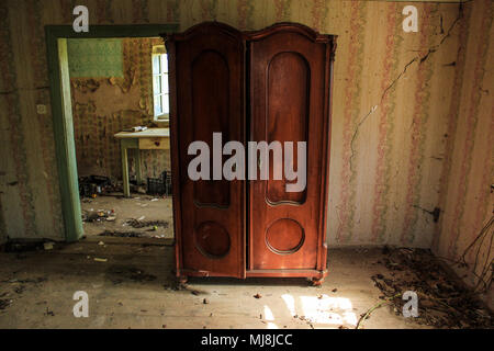 Old wooden wardrobe in an abandoned room Stock Photo