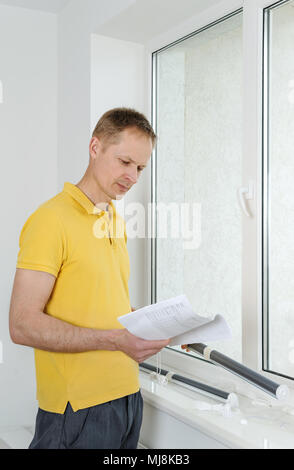 Man is reading instruction for the installation of window blind. Stock Photo