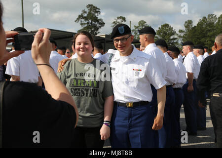 Pvt. Steven Van Acker, an Alaska Army National Guard Soldier from Fairbanks, poses for a photograph with his sister, Deyanira Van Acker, during the Turning Blue Ceremony held on Kennal Field at Fort Benning, Georgia, April 19, 2018. The Turning Blue Ceremony marks a service members’ official acceptance as a U.S. Army Infantry Soldier and is given after a service members’ Infantry training is successfully completed. (U.S. Army National Guard photo by 2nd Lt. Marisa Lindsay/released) Stock Photo