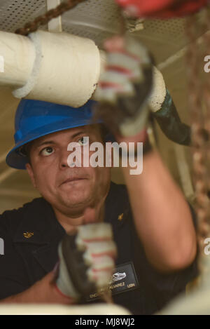 180420-N-NG033-2339 PACIFIC OCEAN (April 20, 2018) Chief Engineman David Alvarez rigs a chain hoist aboard the aircraft carrier USS Theodore Roosevelt (CVN 71). Theodore Roosevelt is currently underway for a regularly scheduled deployment in the U.S. 7th Fleet area of operations in support of maritime security operations and theater security cooperation efforts. (U.S. Navy photo by Mass Communication Specialist Seaman Michael Hogan/Released) Stock Photo