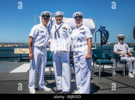 180420-N-NT795-810 SAN DIEGO (April 20, 2018) Electronic Technician 1st Class Jose Martinez assigned to Coastal Riverine Group (CRG) 1 with Chief Yeoman Angel Gabriel and Chief Boatswain’s Mate Mike Velasquez presents his certificate of graduation during The Foundry Class 009 graduation ceremony held onboard USS Midway Museum, in downtown San Diego. The Foundry is a leadership course intentionally designed by senior enlisted Navy leaders with over 150 combined years of service for Navy First Class Petty Officer. (U.S. Navy photo by Chief Boatswain’s Mate Nelson Doromal/Released) Stock Photo