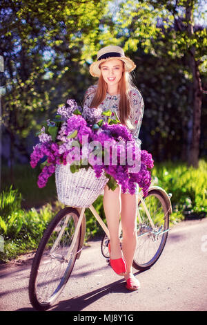 https://l450v.alamy.com/450v/mj8y1g/portrait-of-a-happy-beautiful-young-girl-with-vintage-bicycle-and-flowers-on-city-background-in-the-sunlight-outdoor-bike-with-basket-full-of-flowers-mj8y1g.jpg