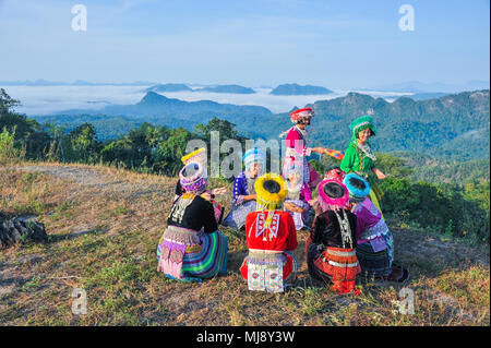 Tak, Thailand - November 11, 2011: Group of beautiful hill tribe girls with their colorful dresses playing traditional game in national public park of Stock Photo