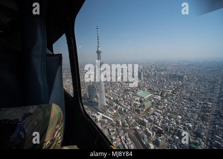 Entertainers view Tokyo city during an aerial helicopter tour aboard UH-1 Huey helicopters from Yokota Air Base, Japan; the first stop on the annual Vice Chairman’s USO Tour, April 22, 2018. Comedian Jon Stewart, country music artist Craig Morgan, celebrity chef Robert Irvine, professional fighters Max “Blessed” Holloway and Paige VanZant, and NBA Legend Richard “Rip” Hamilton will join Gen. Selva on a tour across the world as they visit service members overseas to thank them for their service and sacrifice. (DoD Photo by U.S. Army Sgt. James K. McCann) Stock Photo