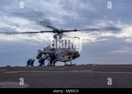 180421-N-VR594-0206 PACIFIC OCEAN (April 21, 2018) Sailors chocks and chains an AH-1Z Cobra assigned to Marine Light Attack Helicopter Squadron (HMLA) 267 on the flight deck of the Harpers Ferry-class amphibious dock landing ship USS Pearl Harbor (LSD 52). Pearl Harbor is currently underway off the coast of Southern California conducting routine training operations. (U.S. Navy photo by Mass Communication Specialist 3rd Class Kelsey J. Hockenberger/Released) Stock Photo