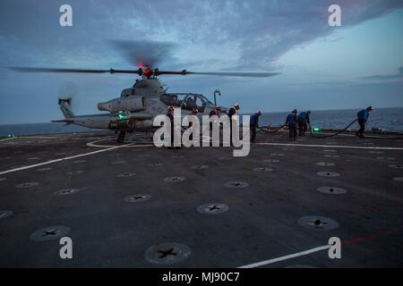 180421-N-VR594-0228 PACIFIC OCEAN (April 21, 2018) Sailors leave the landing area of the flight deck after refueling an AH-1Z Cobra assigned to Marine Light Attack Helicopter Squadron (HMLA) 267 aboard the Harpers Ferry-class amphibious dock landing ship USS Pearl Harbor (LSD 52). Pearl Harbor is currently underway off the coast of Southern California conducting routine training operations. (U.S. Navy photo by Mass Communication Specialist 3rd Class Kelsey J. Hockenberger/Released) Stock Photo