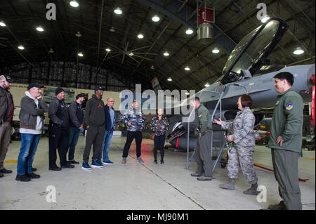 Entertainers check out a 51st Fighter Wing F-16 at Osan Air Base, Republic of Korea; the second stop on the annual Vice Chairman's USO Tour, April 23, 2018. Comedian Jon Stewart, country music artist Craig Morgan, celebrity chef Robert Irvine, professional fighters Max “Blessed' Holloway and Paige VanZant, and NBA Legend Richard “Rip' Hamilton will join Gen. Selva on a tour across the world as they visit service members overseas to thank them for their service and sacrifice. (DoD Photo by U.S. Army Sgt. James K. McCann) Stock Photo