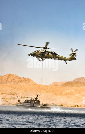 AQABA, Jordan (April 24, 2018) --  A MH-60S with Helicopter Sea Combat Squadron 28 attached to USS Iwo Jima (LHD 7) raises a rescue litter while practicing casualty evacuations procedures with a patrol boat from Royal Jordanian Navy Combat Boats Group during exercise Eager Lion, April 24, 2018.  Eager Lion is a capstone training engagement that provides U.S. forces and the Jordan Armed Forces an opportunity to rehearse operating in a coalition environment and to pursue new ways to collectively address threats to regional security and improve overall maritime security.  (U.S. Navy photo by Mass Stock Photo