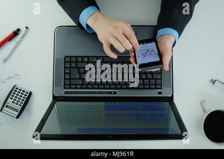 Working on a laptop and using smartphone Stock Photo