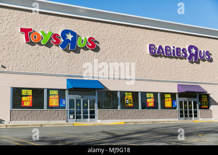 A logo sign outside of a joint Toys 'R' Us and Babies 'R' Us retail store in Annapolis, Maryland with 'Going Out Of Business' signage on April 29, 201 Stock Photo