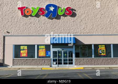 A logo sign outside of a joint Toys 'R' Us and Babies 'R' Us retail store in Annapolis, Maryland with 'Going Out Of Business' signage on April 29, 201 Stock Photo