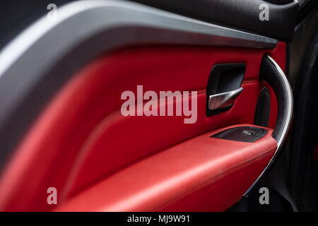 Close-up, shallow focus of the lock and switch mechanism on an door interior. Detail of the red leather interior and lock mech are also in view. Stock Photo