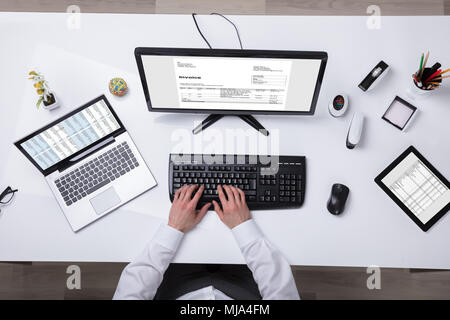 Young Businessman Using Laptop With Computer Screen Showing Invoice Stock Photo