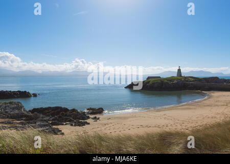 The lighthouse of Twr Mawr Llanddwyn Island, Anglesey and the peaks of the Llyn Peninsular in the distance. Stock Photo