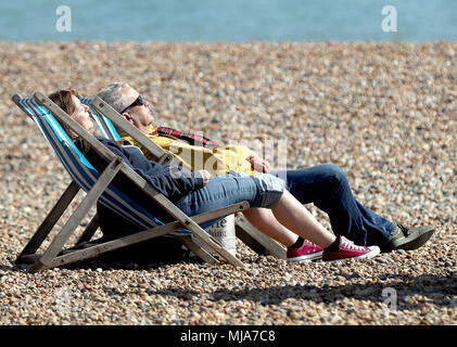 A couple enjoy the afternoon sunshine on the beach in Brighton, as Britons look set to enjoy a spring heatwave, with Bank Holiday Monday forecast to be the hottest ever. Stock Photo