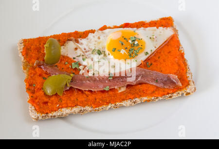 spanish tapa composed by fried quail egg, anchovy, olive, pepper and oregano Stock Photo