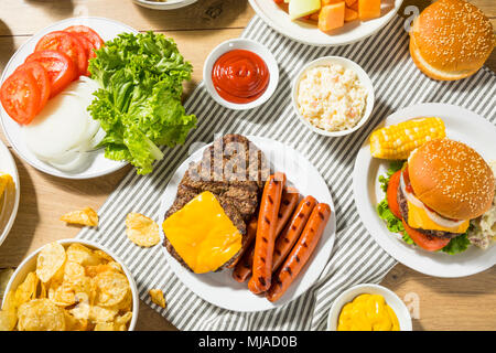 Memorial Day Backyard Babecue Meal with Hamburgers Hot dogs Salads and Chips