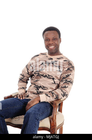 A smiling African American man in jeans and a sweater sitting  on chair looking into the camera, isolated for white background Stock Photo