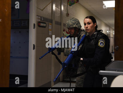 Georgia McCullough, Department of the Air Force officer, front, and Senior Airman Thomas Cruise, 82nd Security Forces Squadron patrolman, run down the hallway during an active shooter exercise at the elementary school on Sheppard Air Force Base, Texas, April 20, 2018. During the drill, Response Team members were evaluated on how thorough they were when searching, how quickly they eliminated any threats and how well they followed safety regulations. (U.S. Air Force photo by Airman 1st Class Pedro Tenorio) Stock Photo