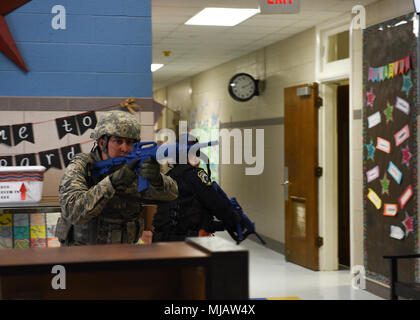 Senior Airman Thomas Cruise, 82nd Security Forces Squadron patrolman, and Georgia McCullough, Department of the Air Force officer, rush through the front door at Sheppard Elementary School during an active shooter drill on Sheppard Air Force Base, Texas, April 20, 2018. To simulate a real active shooter, the first response team would not wait for backup. That would result in teams of only two or sometimes one, to go into the area and neutralize the threat alone. (U.S. Air Force photo Airman 1st Class Pedro Tenorio) Stock Photo