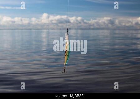 wobbler on the fishing line against the blue sea Stock Photo
