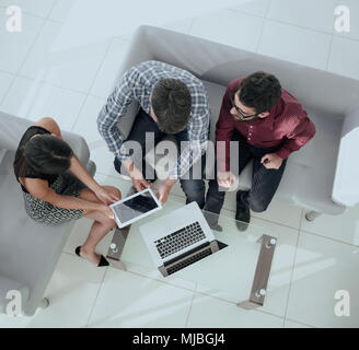 startup business team on meeting in modern bright office interior brainstorming, working on laptop and tablet computer top view Stock Photo