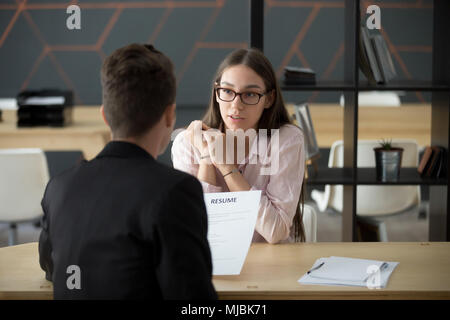 Confident millennial female applicant talking at job interview a Stock Photo