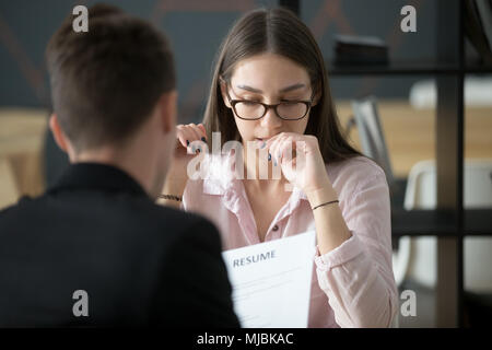 Stressed applicant nervous at job interview while hr reading res Stock Photo