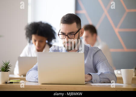 Serious businessman focused on computer online work in coworking Stock Photo