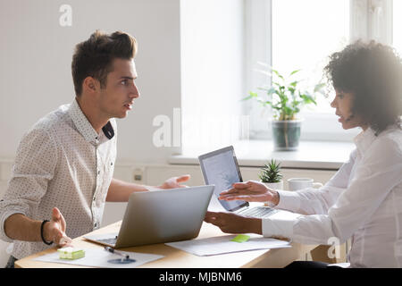 Multiracial colleagues arguing about document disagreeing having Stock Photo