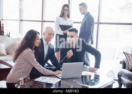 Young team of coworkers making great business discussion in modern coworking office. Teamwork people concept. Stock Photo
