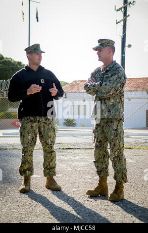 180430-N-PE825-0056 NAVAL STATION ROTA, Spain (April 30, 2018) – Capt. Cameron Geertsema, commander, 22nd Naval Construction Regiment, right, speaks with Ensign Jorge Ortiz-Centeno, a Seabee assigned to Naval Mobile Construction Battalion (NMCB) 11, during a tour of Camp Mitchell, Naval Station Rota, Spain, April 30, 2018. NMCB-11 is forward-deployed to execute construction, humanitarian and foreign assistance, special operations combat service support, and theater security cooperation in the U.S. 6th Fleet area of operations. (U.S. Navy photo by Mass Communication Specialist 1st Class Collin  Stock Photo
