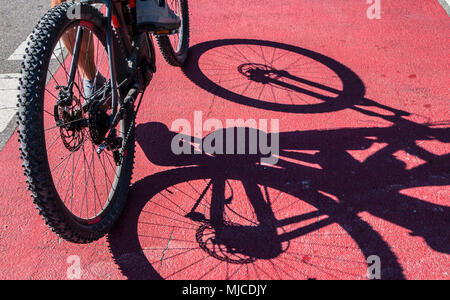 bikers shadow on a red road Stock Photo