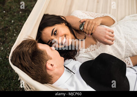 Merry happy young couple hugging in a hammock. Close-up. Stock Photo