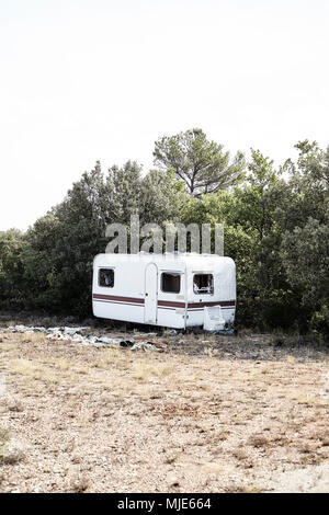 Old caravan in a forest, garbage, plastic Stock Photo