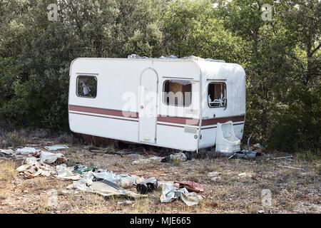 Old caravan in a forest, garbage, plastic Stock Photo