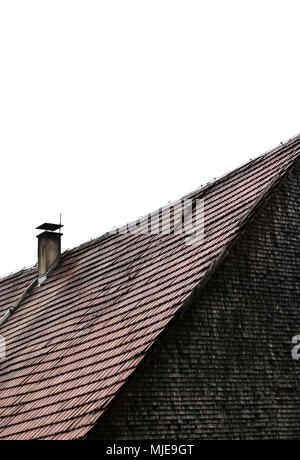 Roof with bricks, fireplace and old shingles, grey weathered on a wooden house in the Black Forest Stock Photo