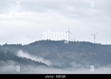 three wind turbines on a mountain in the Black Forest, forest, rain and fog Stock Photo