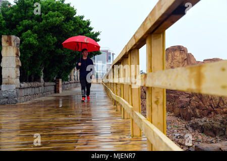 Qingdao, China's Shandong Province. 5th May, 2018. A man visits a seaside pedestrian walkway at Taipingjiao Park in Qingdao, east China's Shandong Province, May 5, 2018. Credit: Guo Xulei/Xinhua/Alamy Live News Stock Photo