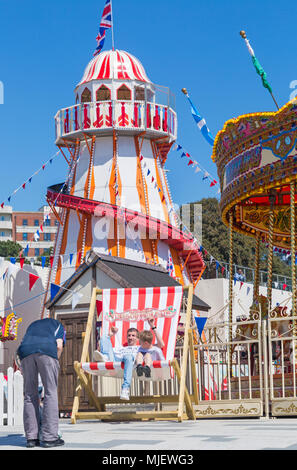 Bournemouth, Dorset, UK. 5th May 2018. UK weather: crowds flock to the seaside to enjoy the unbroken blue skies and sunshine on the first day of the long Bank Holiday weekend. A big deckchair! Old vintage fairground at Pier Approach. Credit: Carolyn Jenkins/Alamy Live News Stock Photo