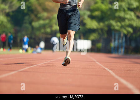 young asian man male athlete running training exercising on track. Stock Photo
