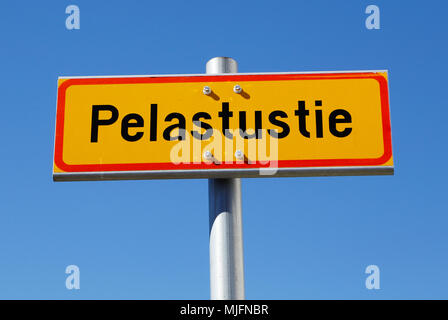 Finnish emergency exit sign (Pelastustie) in Finnish on a pole against blue sky. Stock Photo