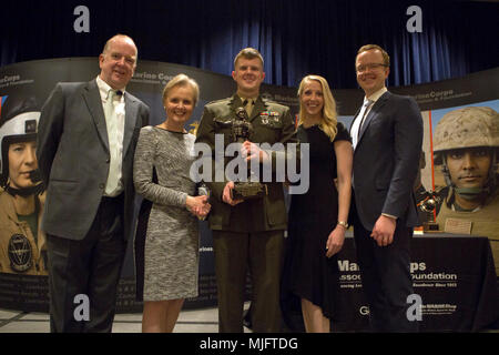 Capt. Joshua B. Kelly, a logistician with 25th Marine Regiment, 4th Marine Division, Marine Forces Reserve, poses with his family after receiving the 1st Lieutenant Travis Manion Memorial Marine Corps Officer Logistician of the Year Award at the Marine Corps Association and Foundation's 14th annual Ground Logistics Awards Dinner at the Crystal Gateway Marriott, Arlington, Virginia, March 22, 2018. Kelly was given the award in part for his efforts towards providing new and advanced means of logistical support within his unit during the 2017 fiscal year. (U.S. Marine Corps Stock Photo